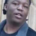 Close-up of a person in a dark jacket, looking slightly off-camera.