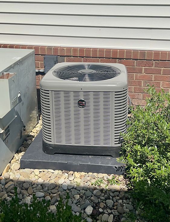a gray air conditioner is sitting outside of a brick building