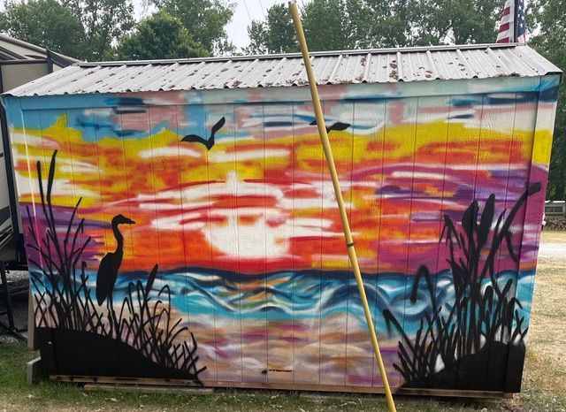 Brightly colored mural of the beach at sunset with bird