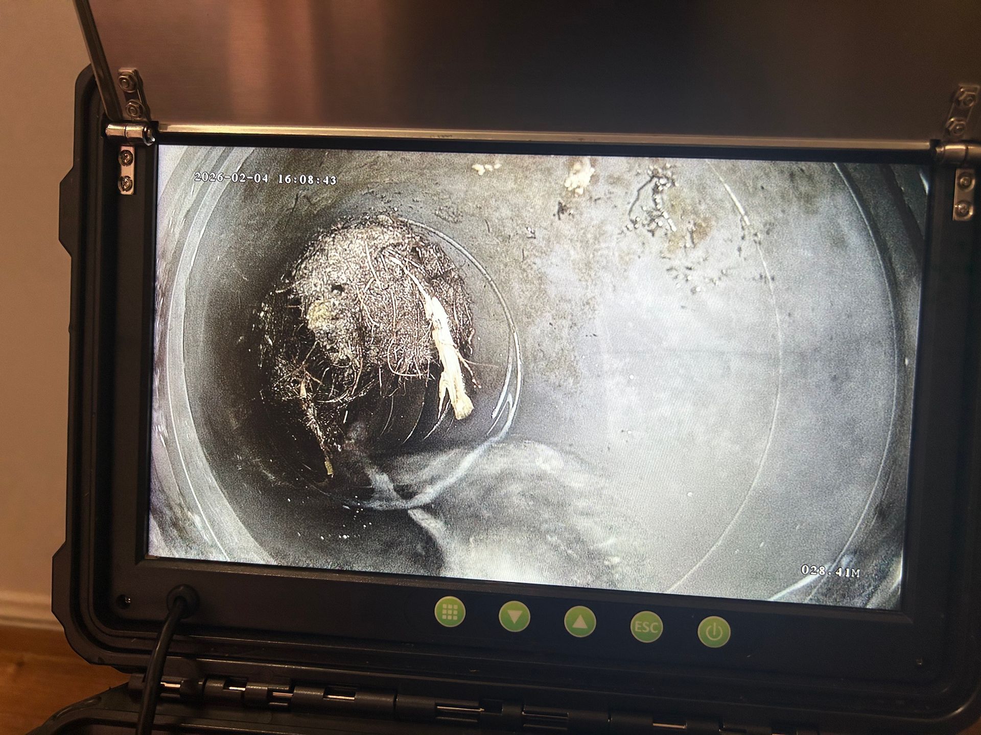 A sewer inspection camera monitor displaying a pipe obstruction with debris and a light-colored object inside — No. 2 Plumbing in Kenmore, QLD