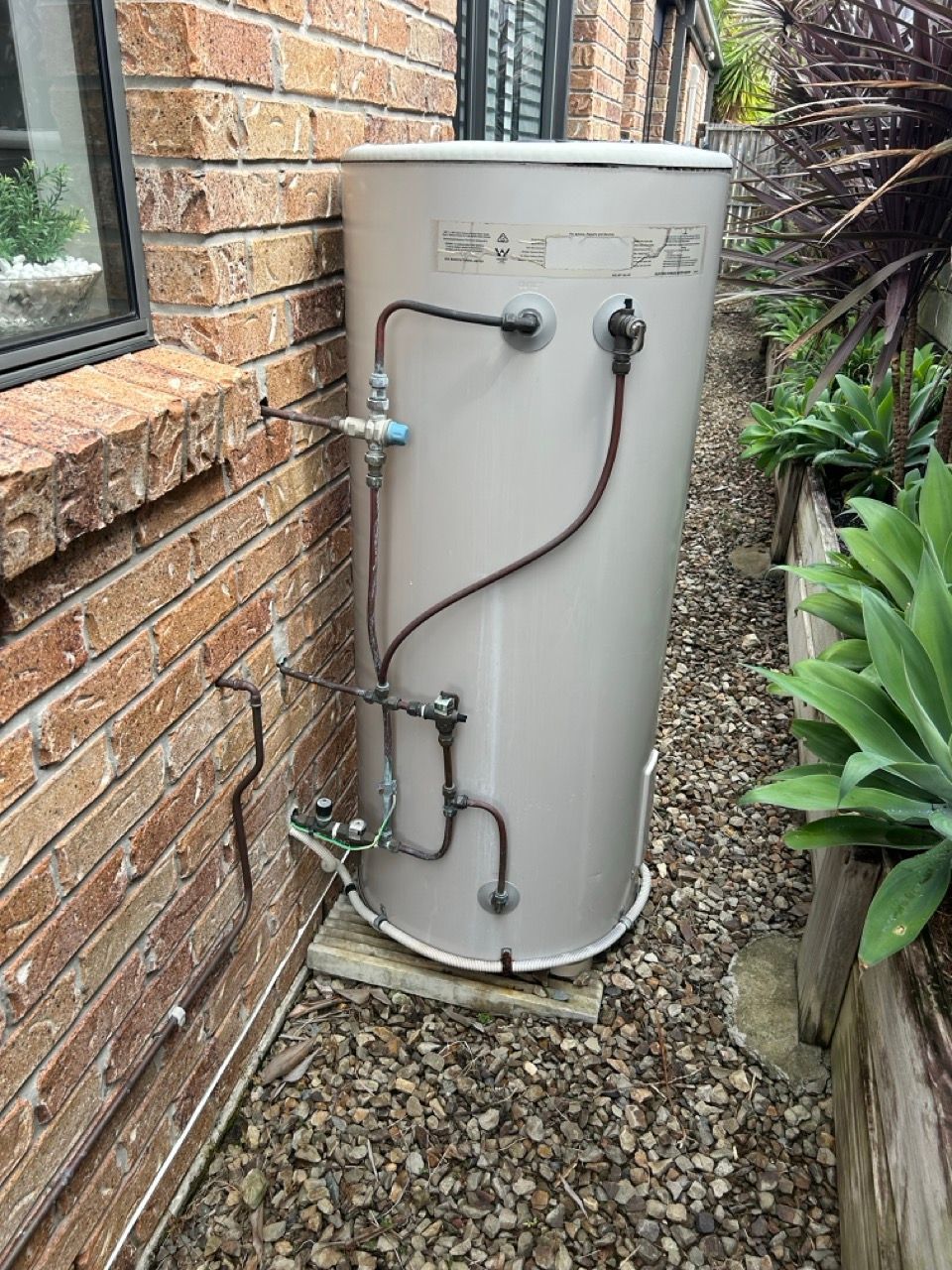 A Light-colored Outdoor Hot Water Cylinder Standing on a Concrete Pad — No. 2 Plumbing In Kenmore, QLD