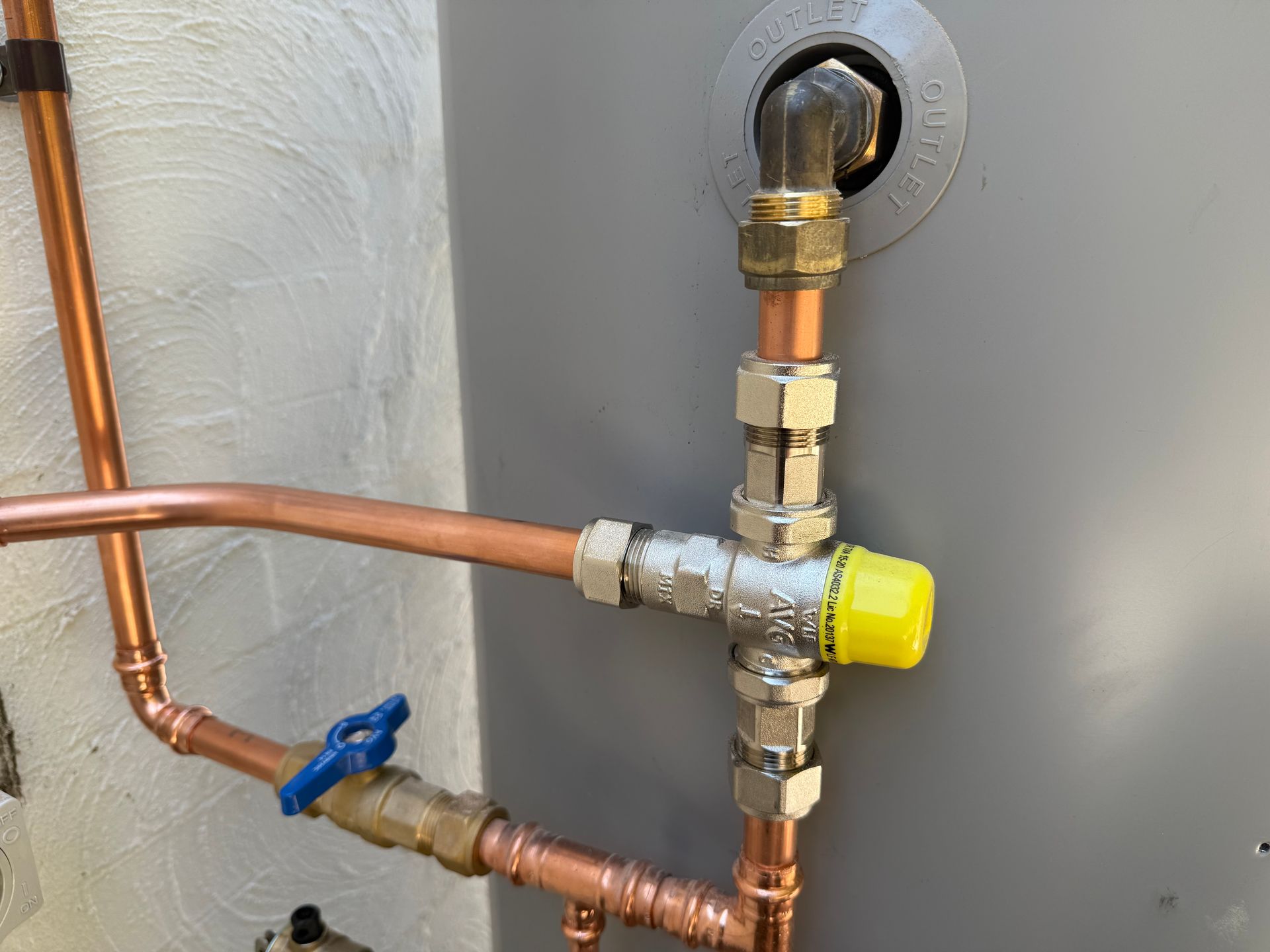 Copper plumbing with a yellow valve connected to a gray water heater. — No. 2 Plumbing In Kenmore, QLD