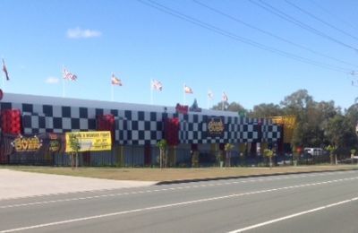 A large building with a checkered pattern is sitting next to a road.