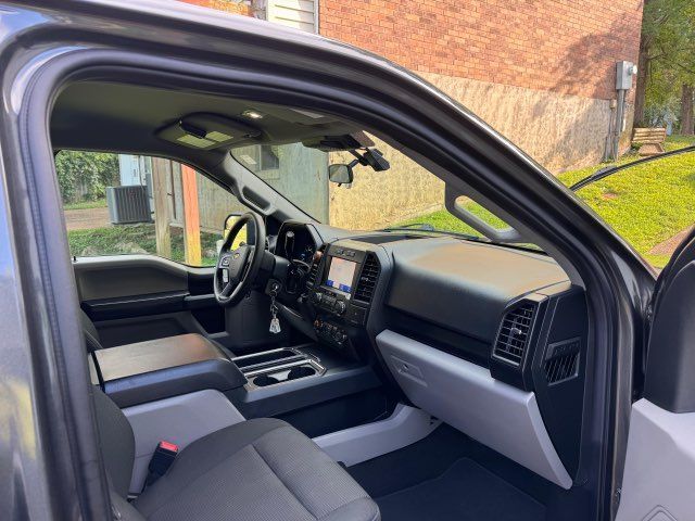 The interior of a ford f150 truck is shown with the door open.