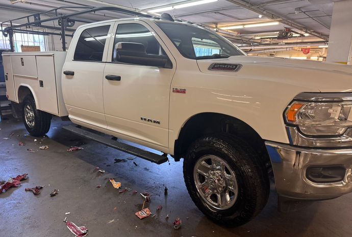 A white ram truck is parked in a parking garage.