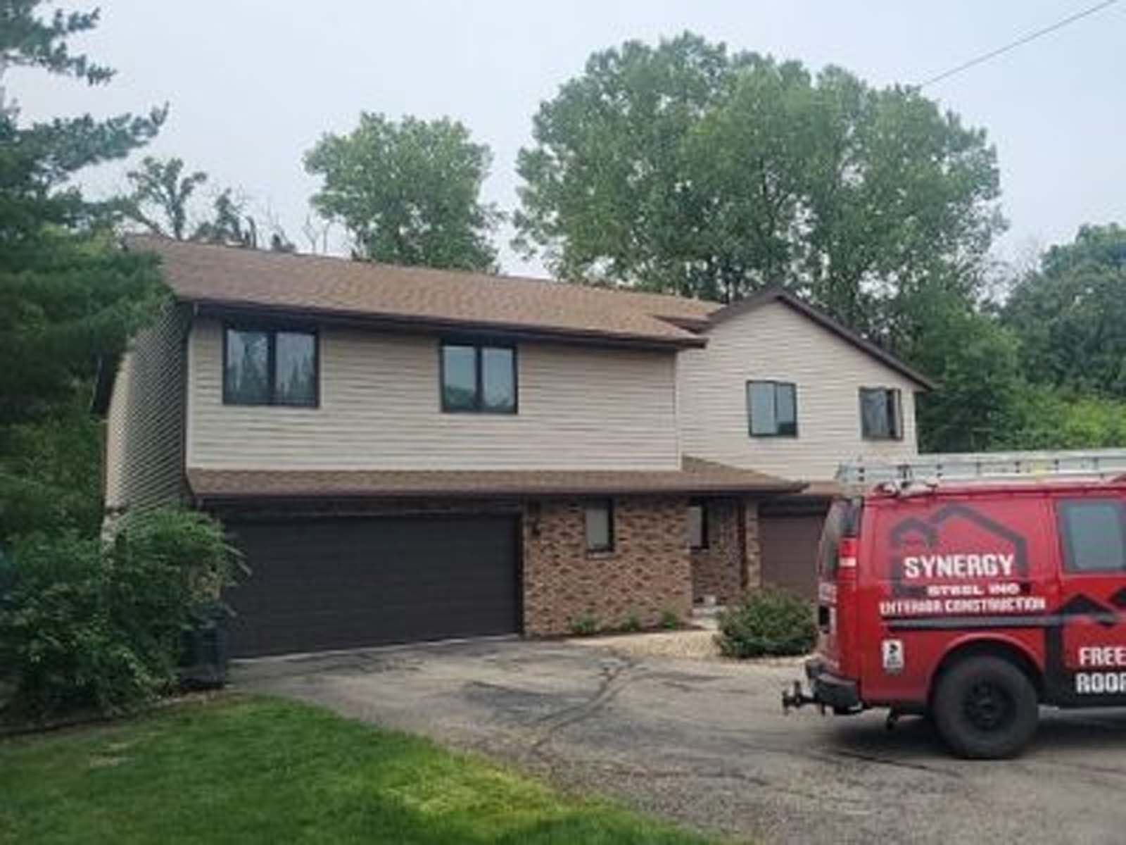 A red van is parked in front of a house.