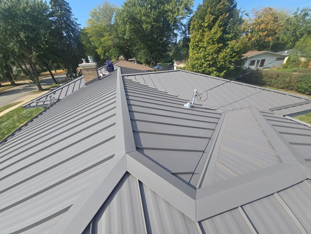 A roof with a chimney on it and a river in the background.