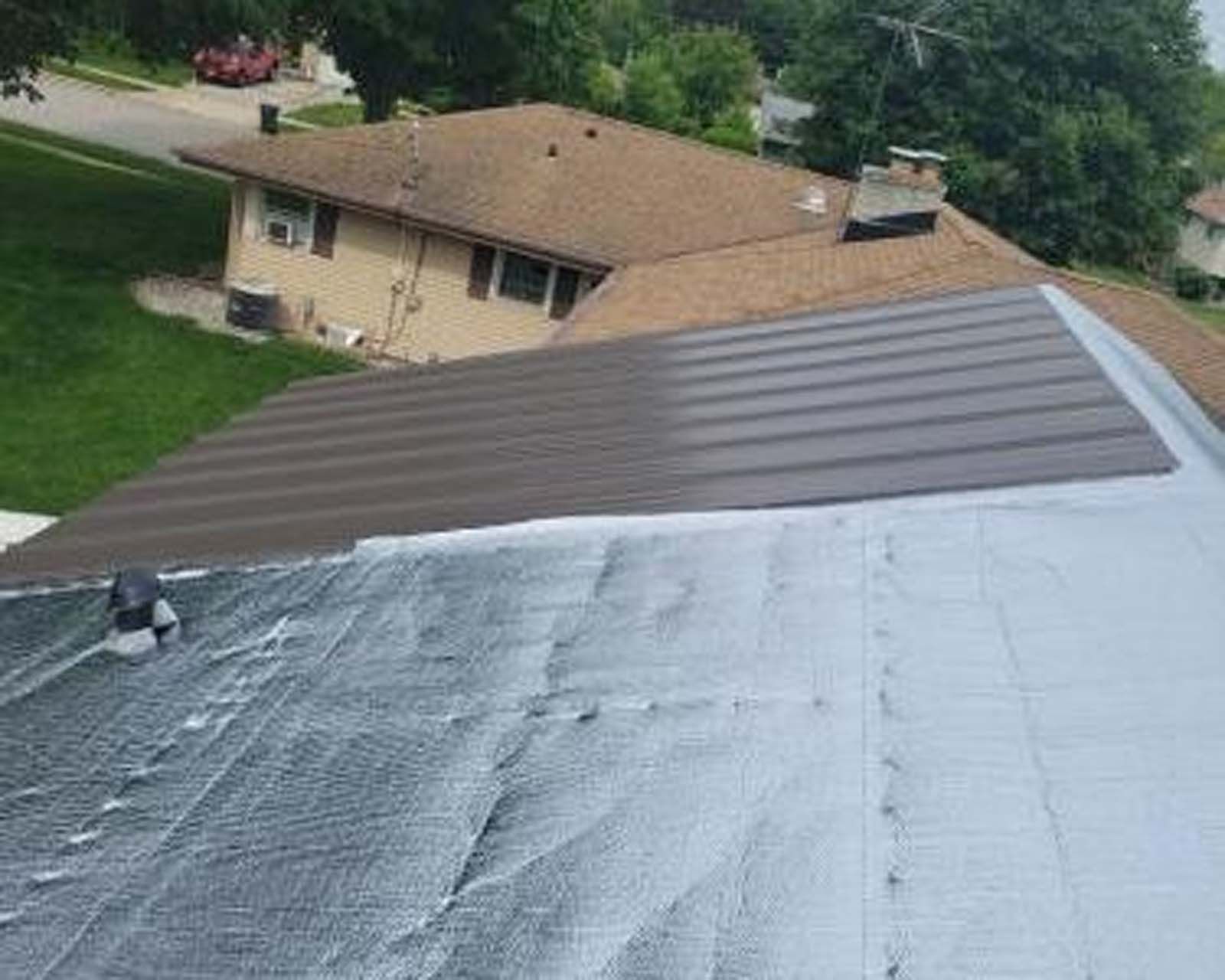 The roof of a house is being painted white.
