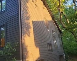 A large house with a lot of windows is surrounded by trees.