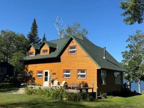 A large wooden house with a green roof