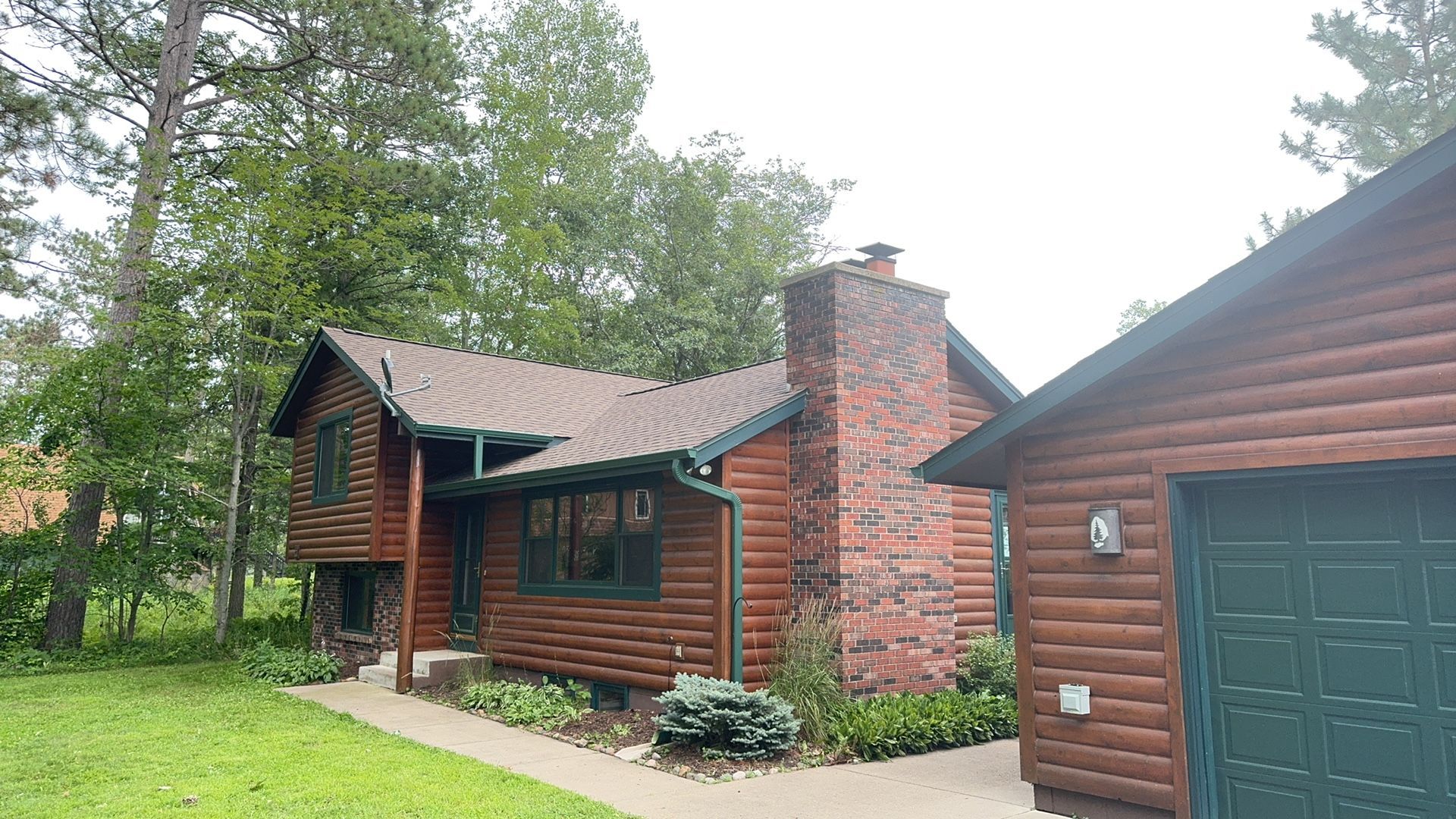 A log cabin with a garage next to it
