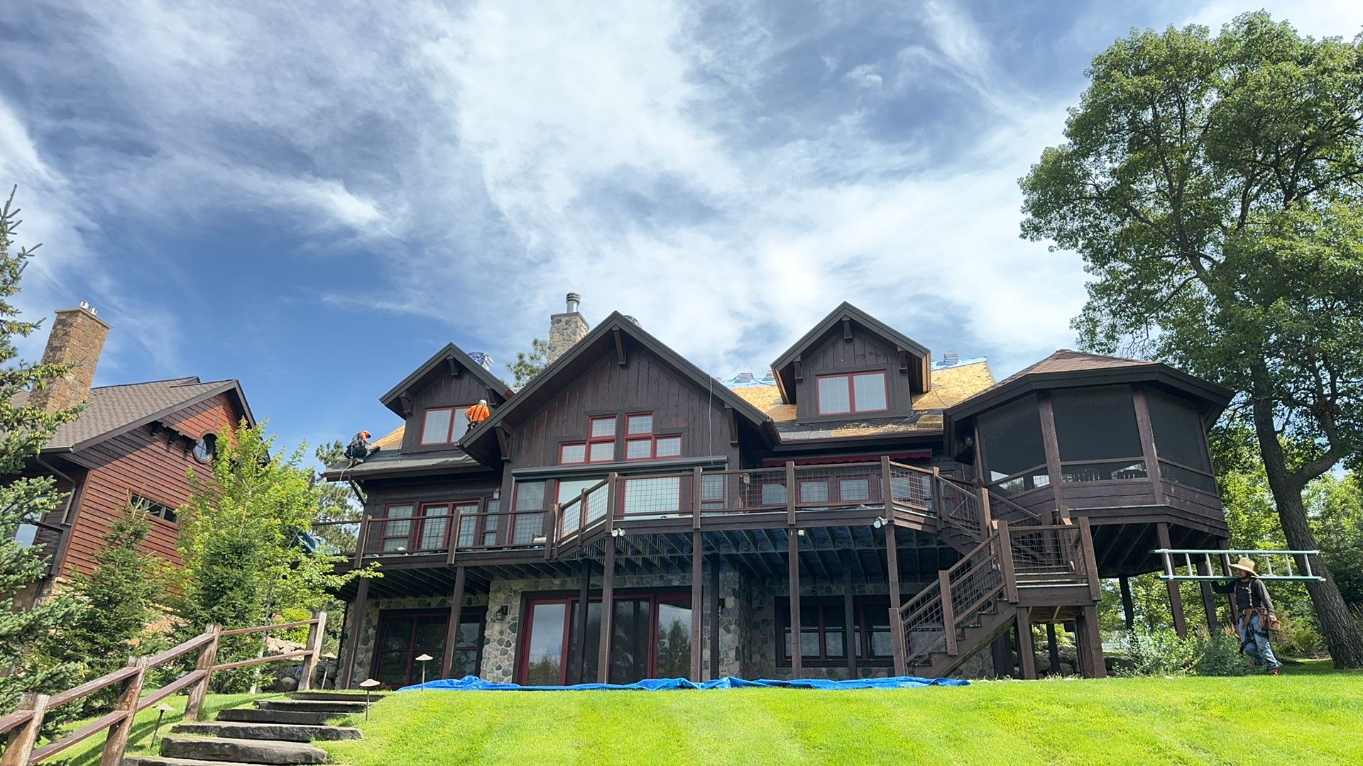 A large house is sitting on top of a lush green hill.
