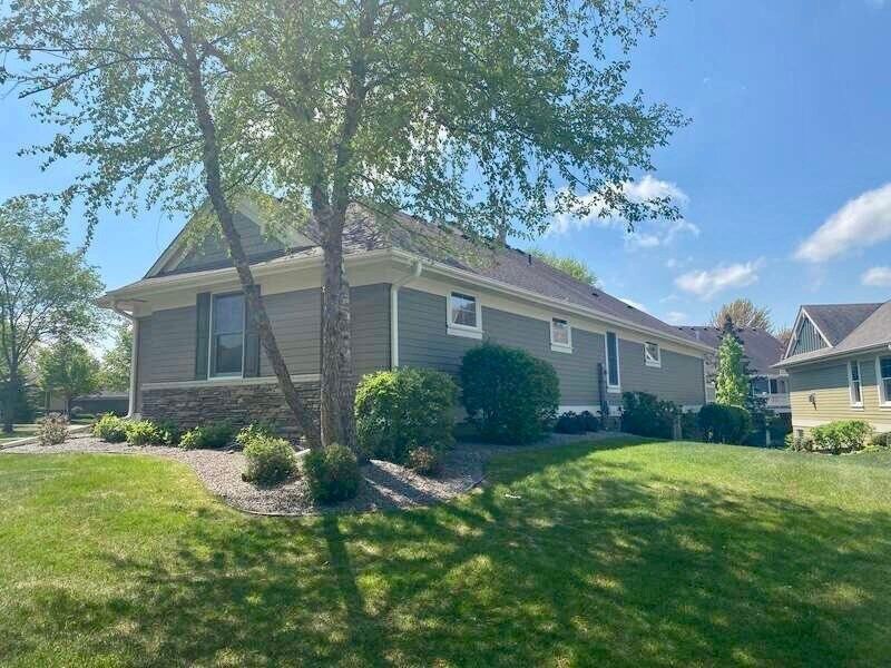 A house with a tree in front of it on a sunny day.