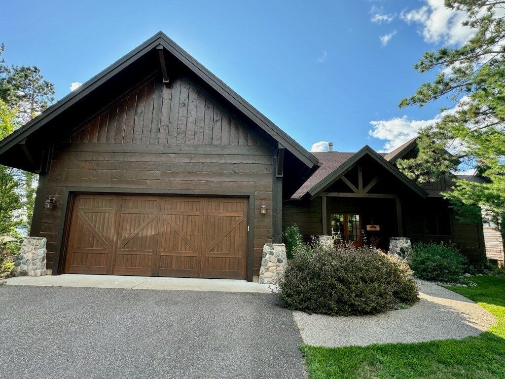 A large wooden house with a large garage door