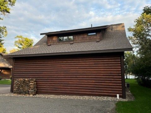 A log cabin with a roof that is covered in shingles