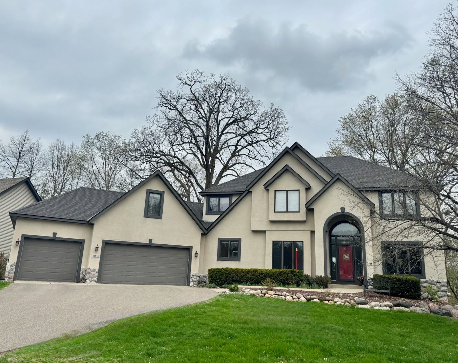 A large house with three garages and a red door