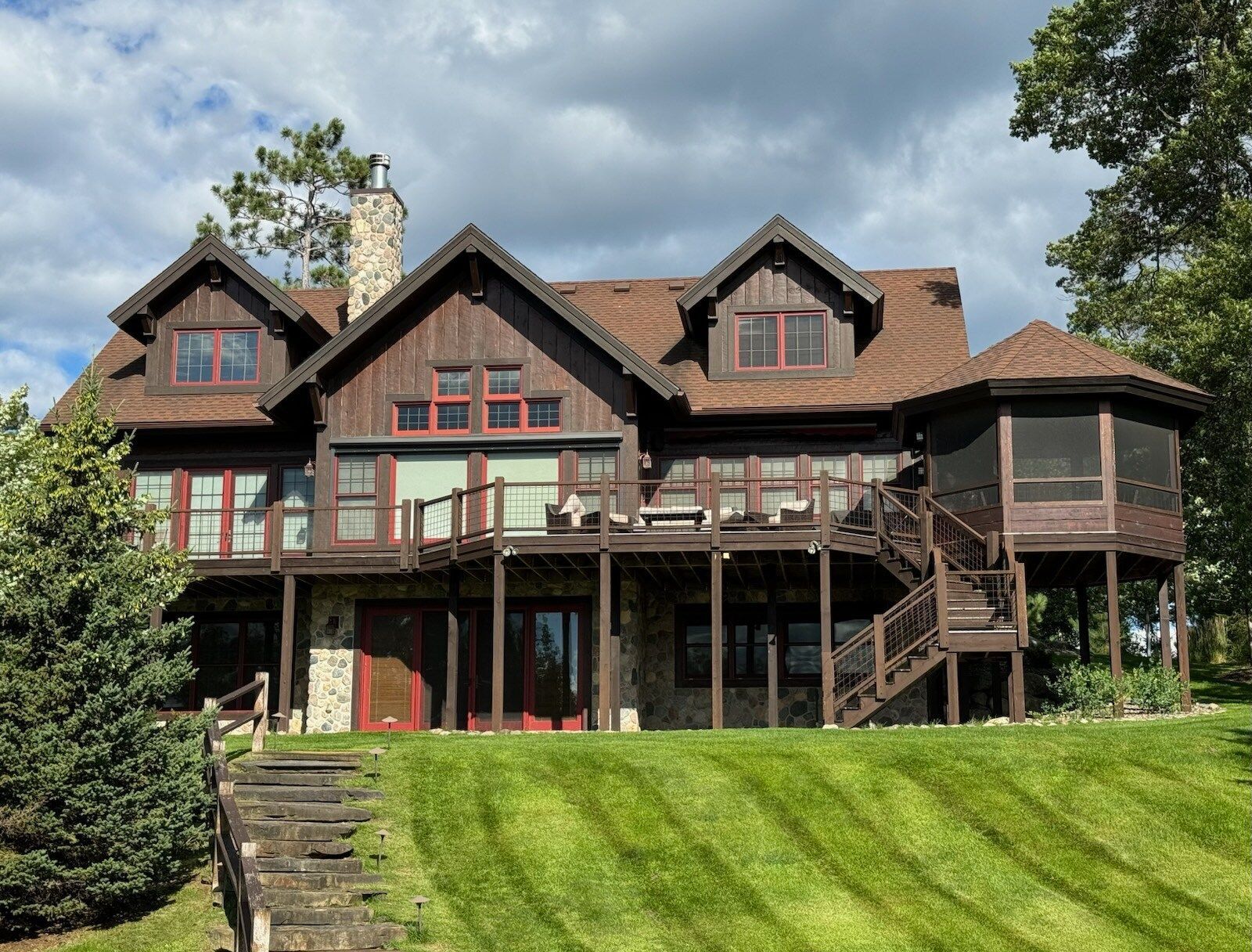 A large house is sitting on top of a lush green hill.