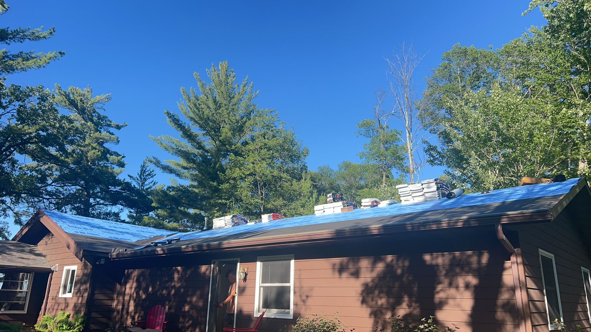 A house with a blue tarp on the roof.