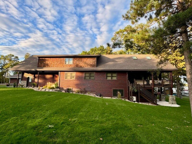A large log cabin with a large lawn in front of it
