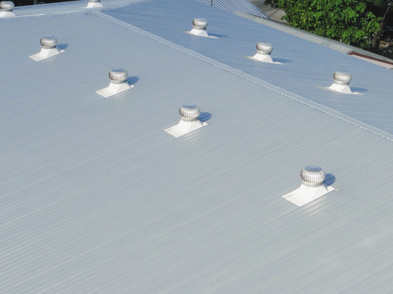 Metal roof with several rotating ventilation devices.