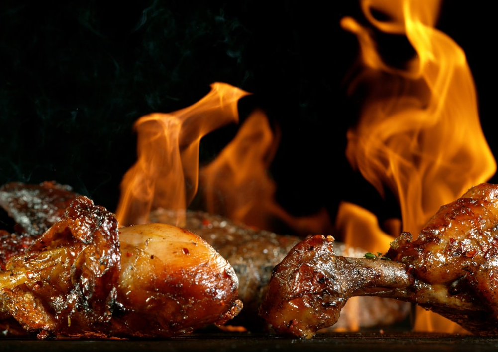 Spaghetti con gamberi, salsa di pomodoro e prezzemolo guarniti su un piatto rettangolare con sfondo blu.