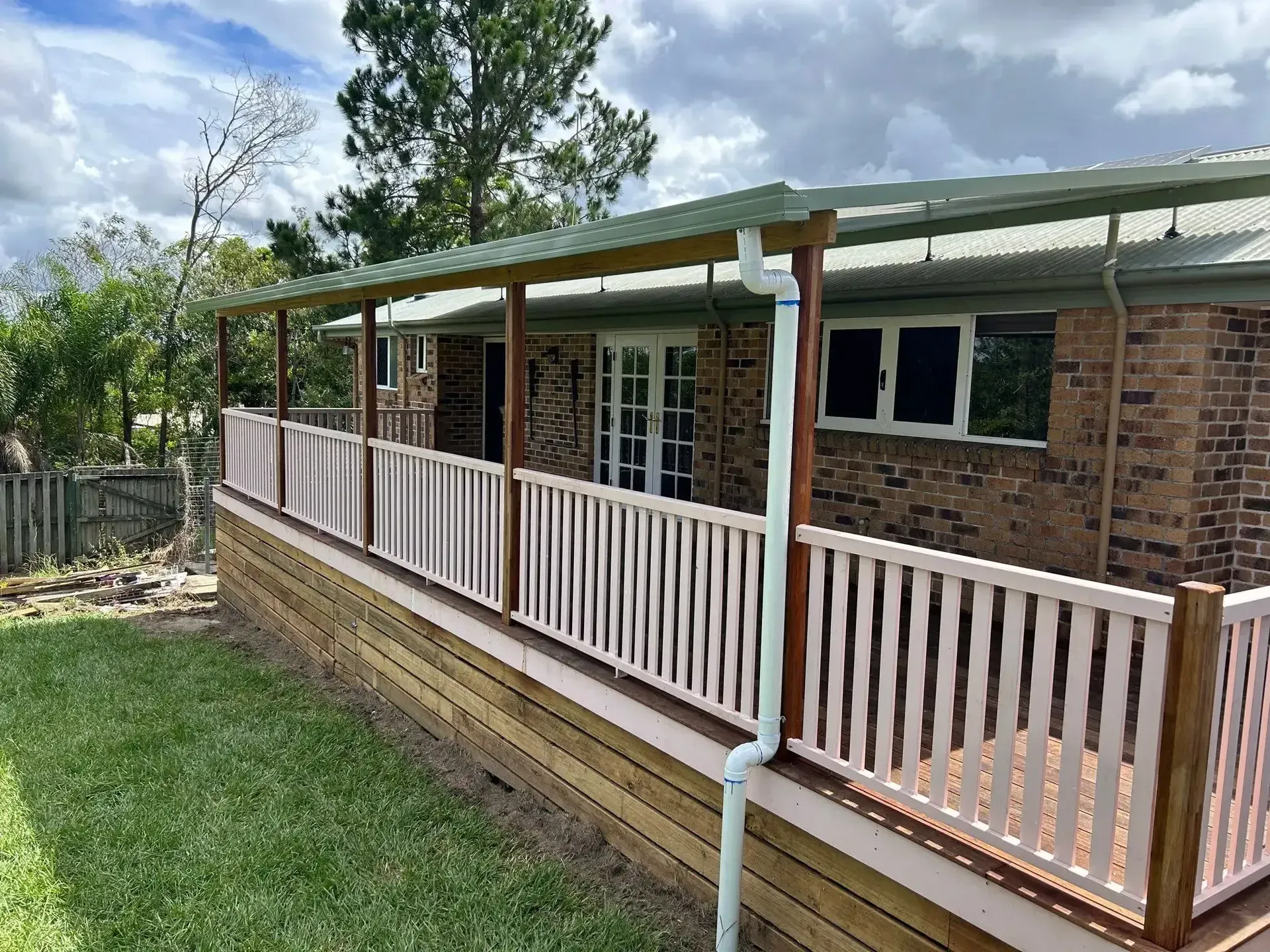 A Wooden Deck Is Being Built In The Backyard Of A House — Jordan Building & Construction Pty Ltd in Ascot, QLD