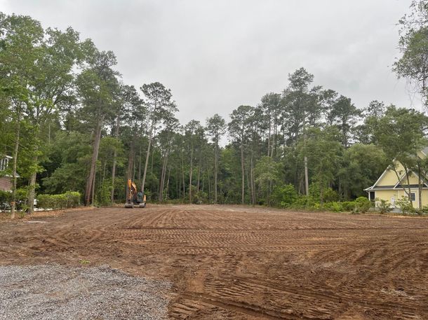 A bulldozer is clearing trees in a forest.