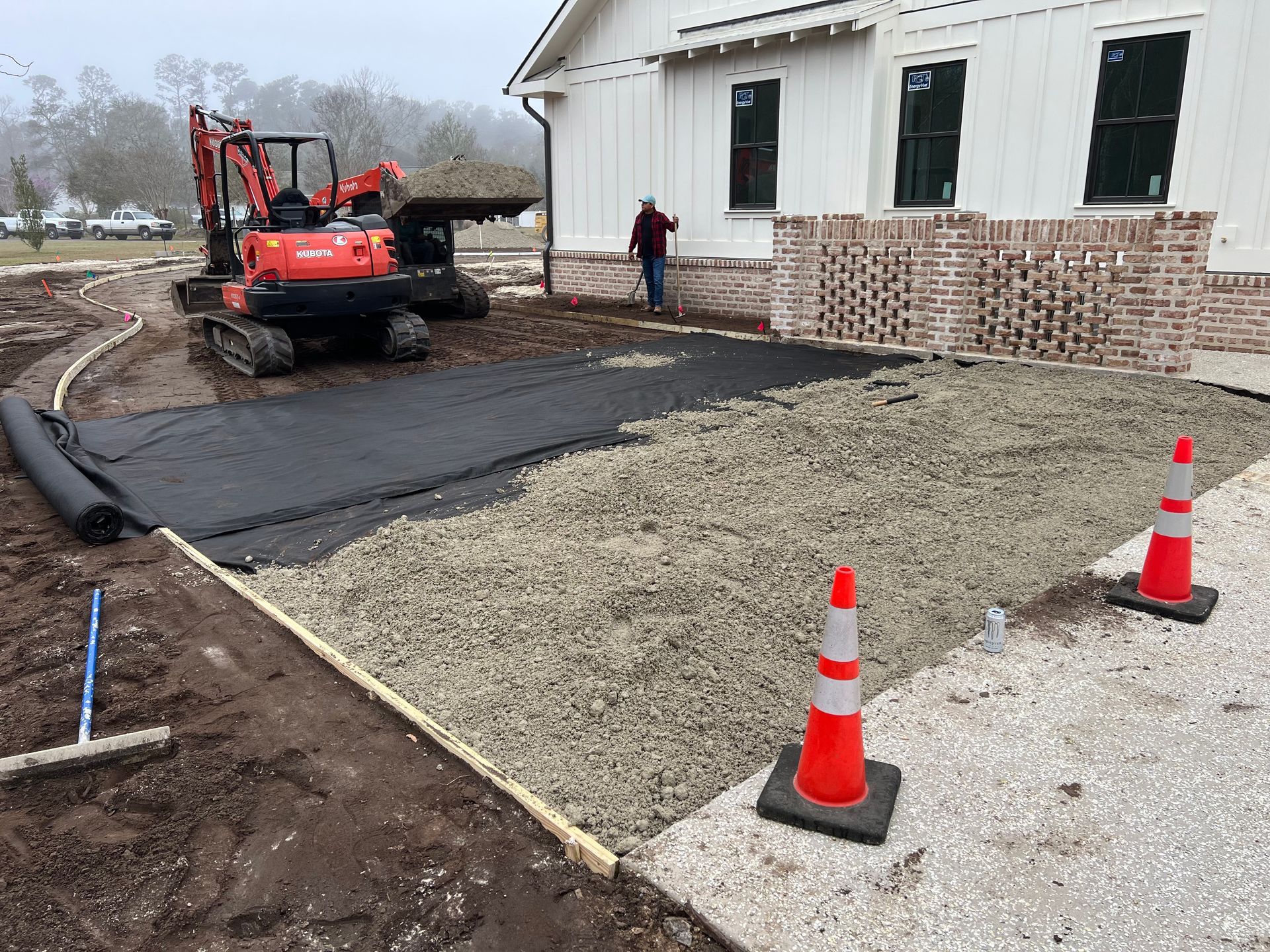 A bulldozer is working on a dirt field in front of a house.