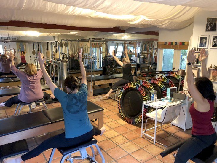 A group of people are doing exercises in a studio.