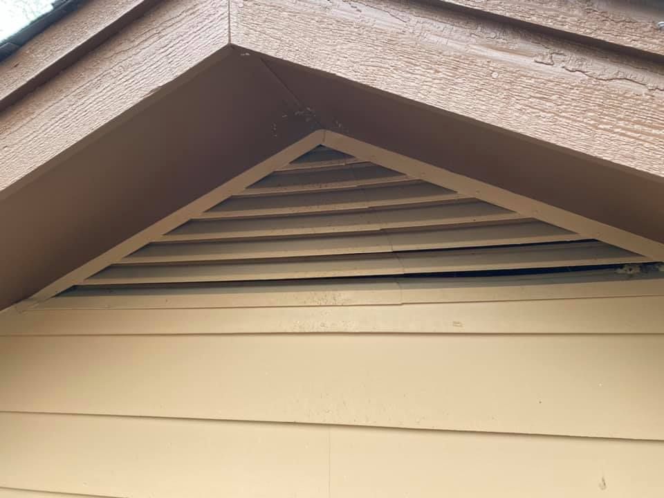 A close up of a vent on the side of a house.
