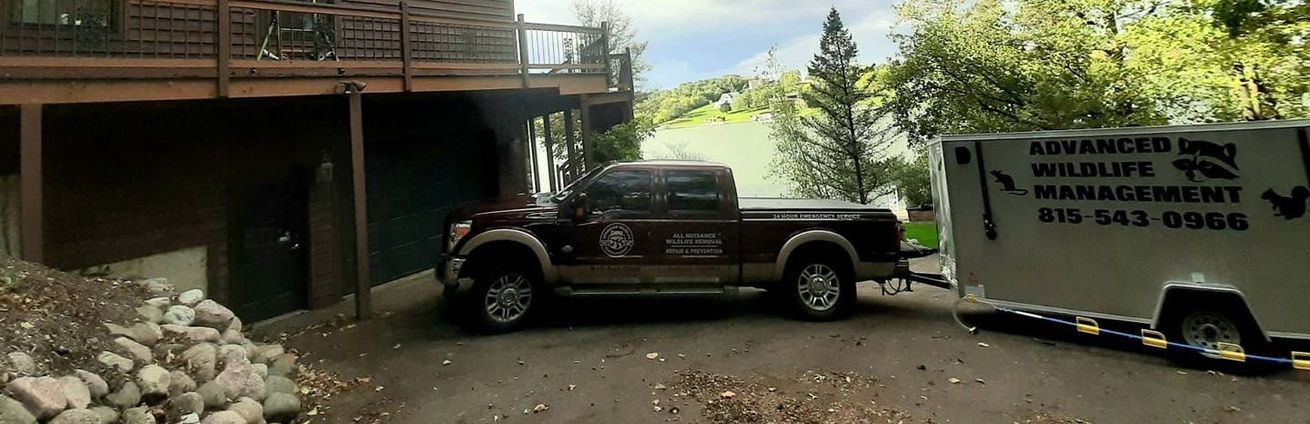 A truck and trailer are parked in front of a house.