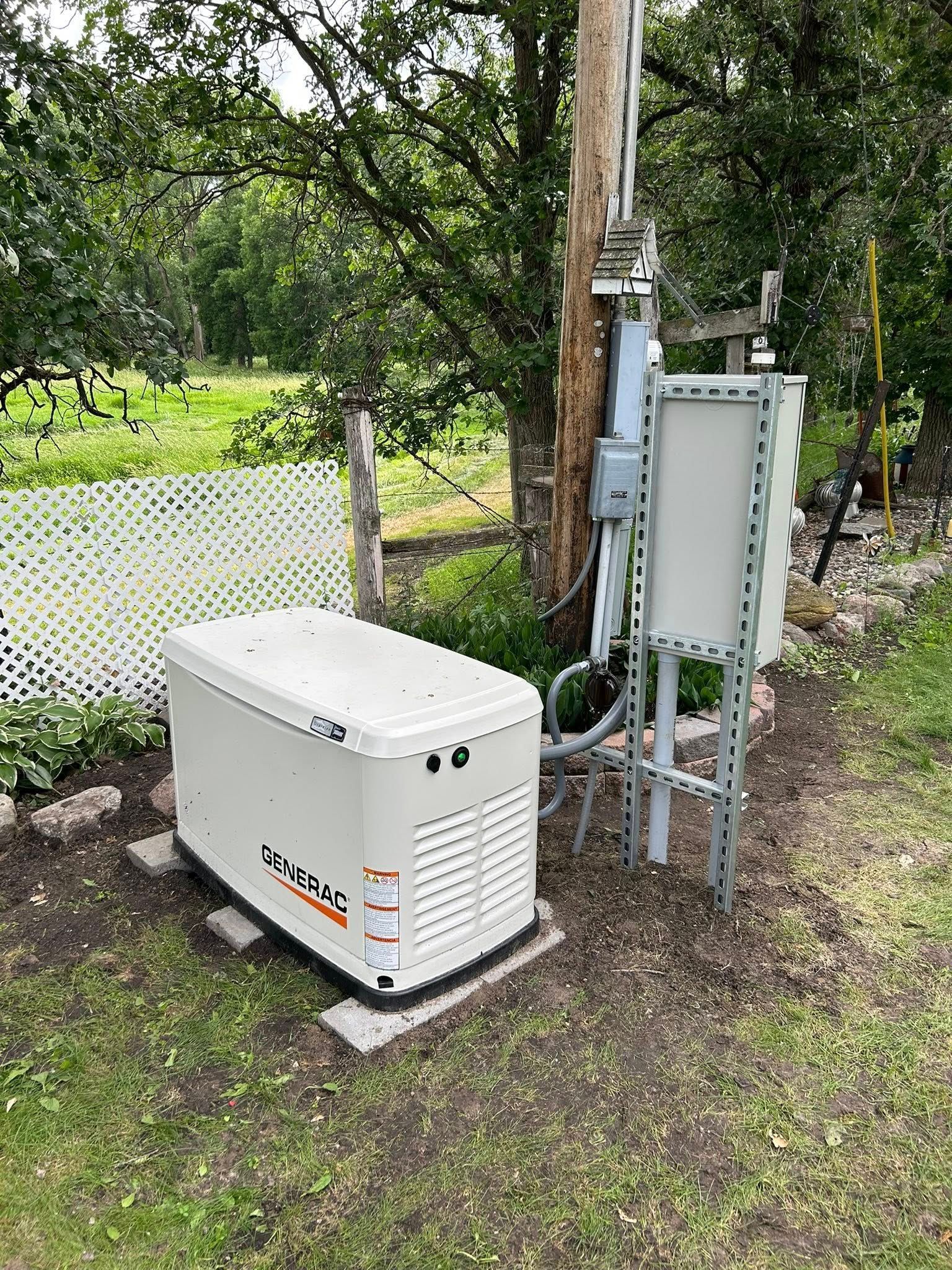 A standby generator next to a utility pole in a yard.