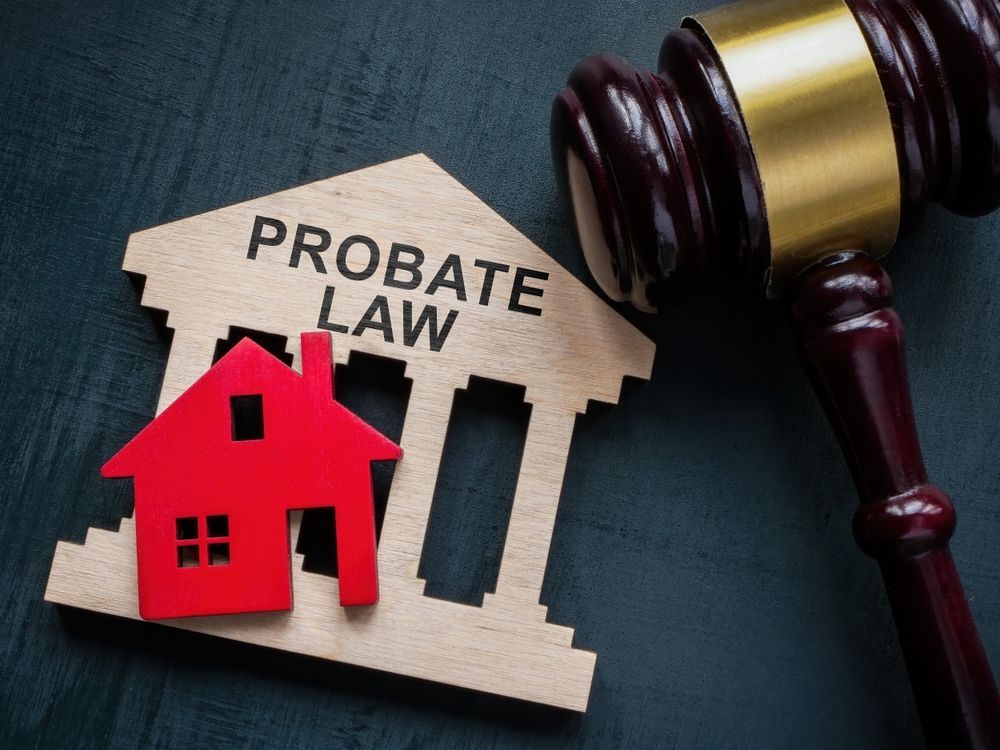 A wooden house and a wooden gavel with the words probate law written on it.
