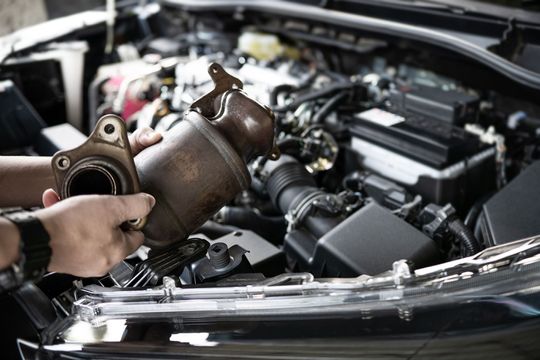 A person is working on the engine of a car.