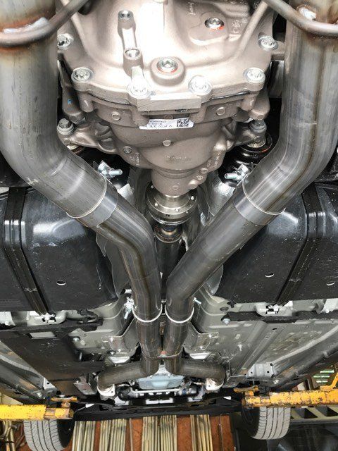 A close up of the underside of a car with exhaust pipes