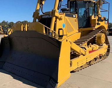 A large yellow bulldozer is parked on the side of the road.