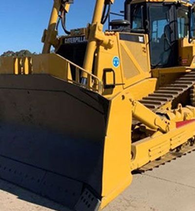 A yellow bulldozer is parked on the side of the road.