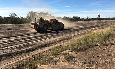 A bulldozer is driving down a dirt road.
