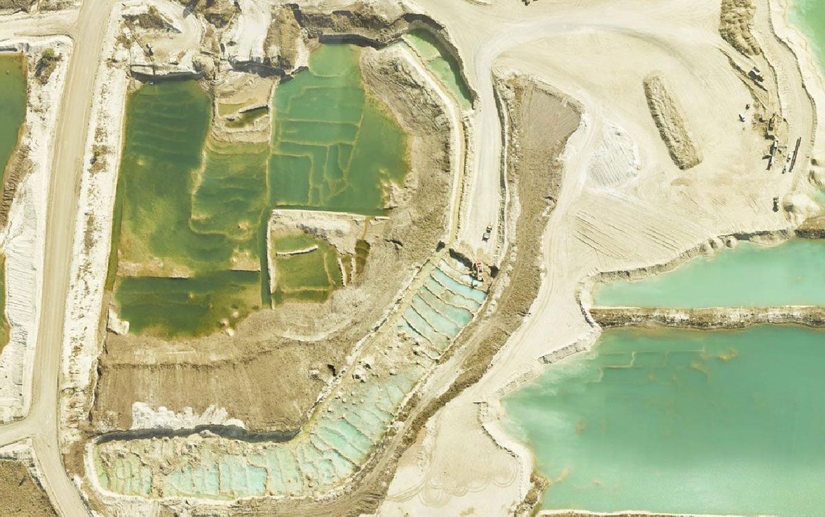 An aerial view of a large body of water surrounded by sand and dirt.