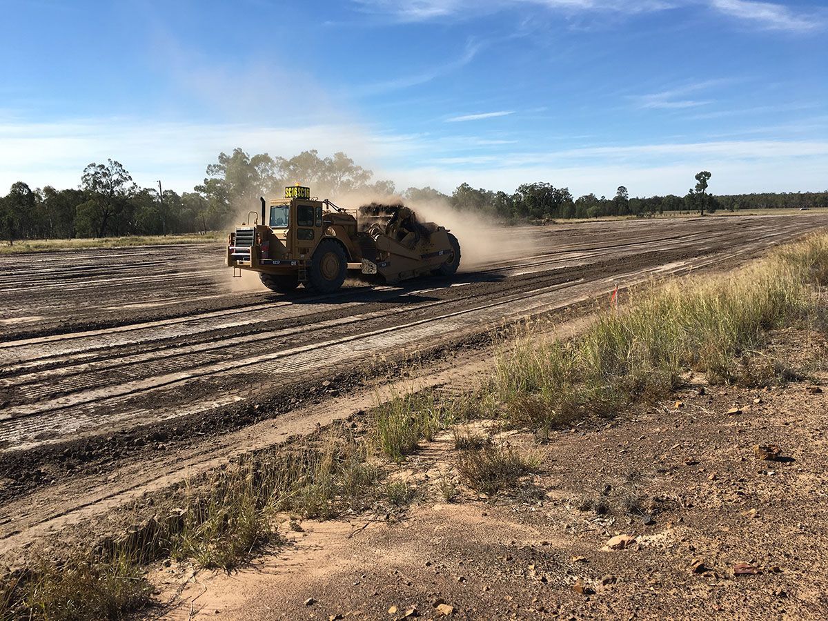 A bulldozer is driving down a dirt road.
