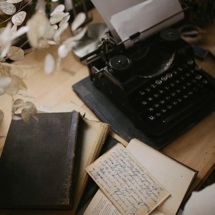 A typewriter is sitting on a table next to a book