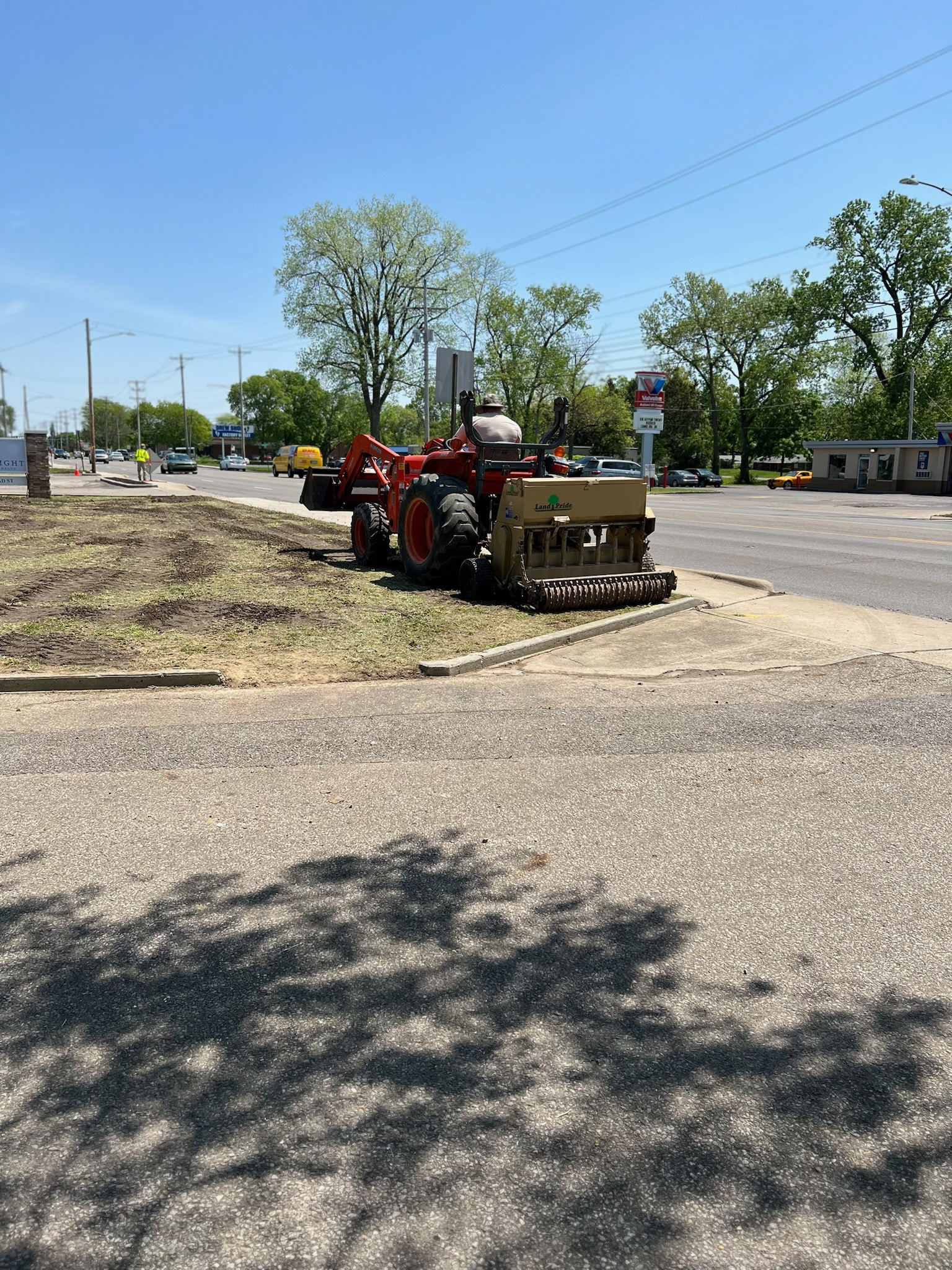A red tractor is parked on the side of the road.