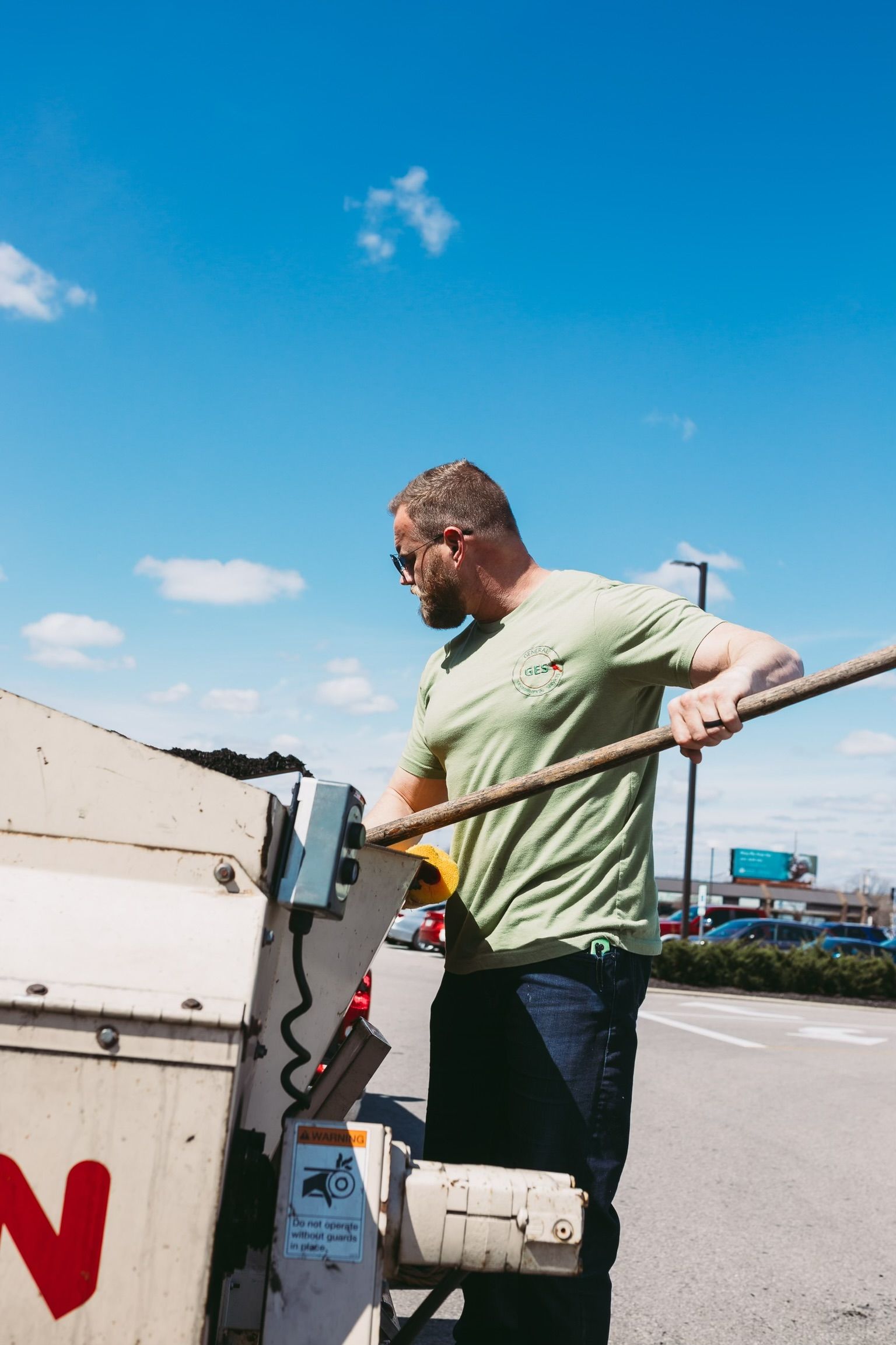 A man in a green shirt is working on a machine.