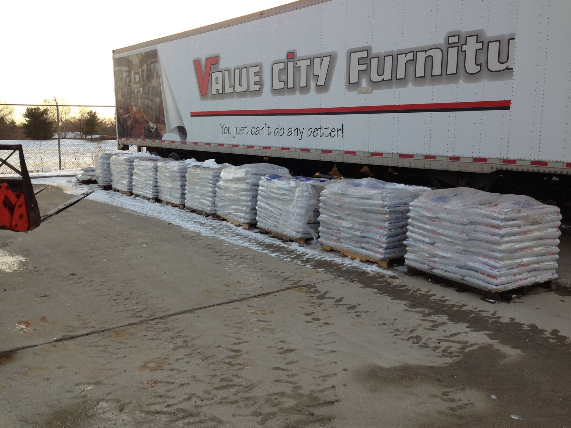 A white value city furniture truck is loaded with bags of gravel