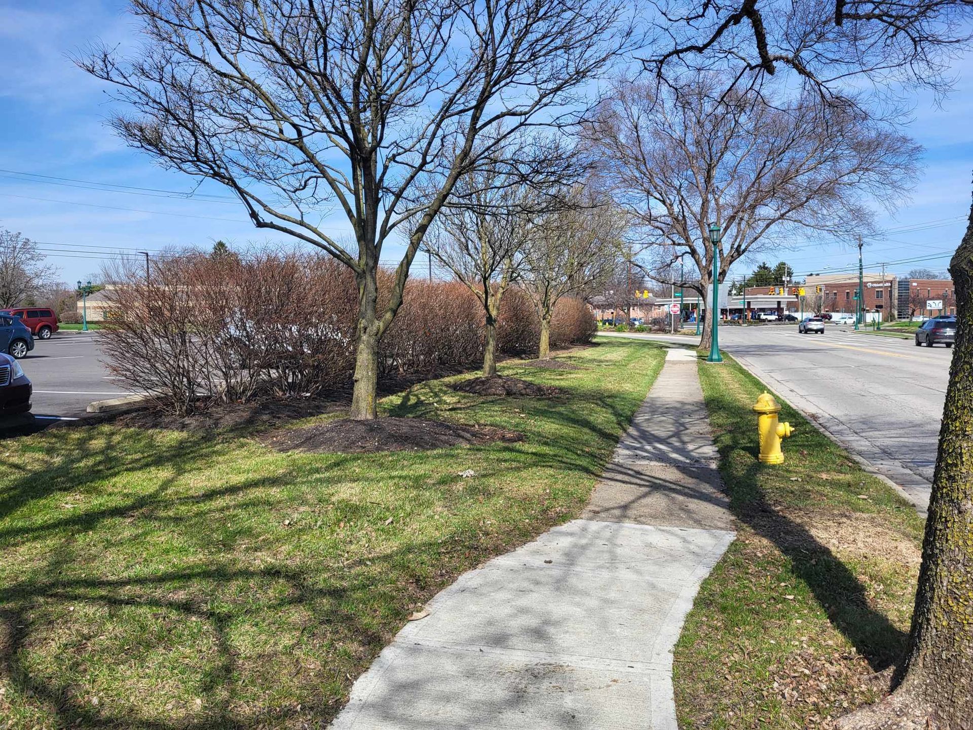 There is a fire hydrant on the side of the road next to a sidewalk.