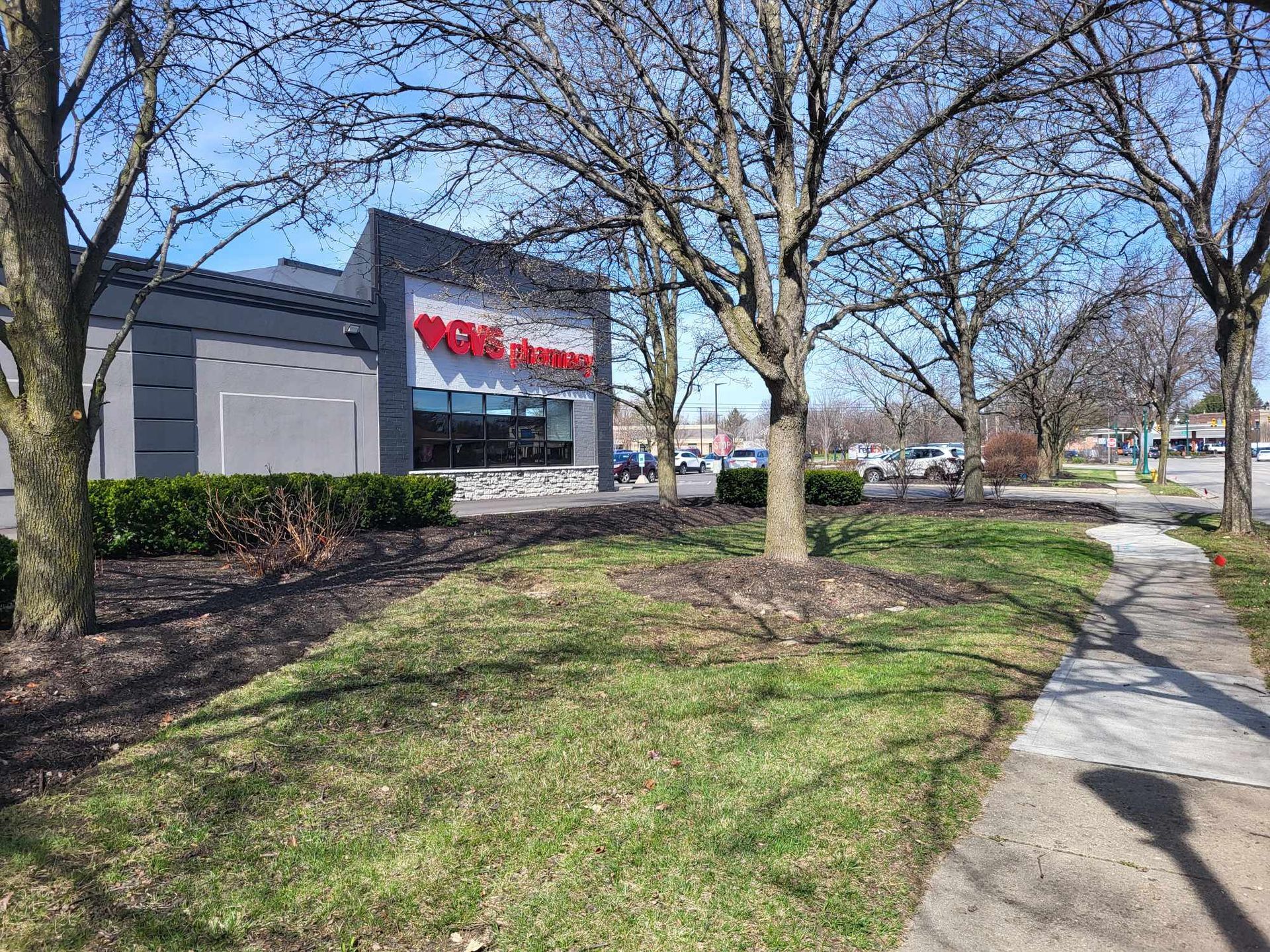 A walkway leading to a store with trees in front of it.