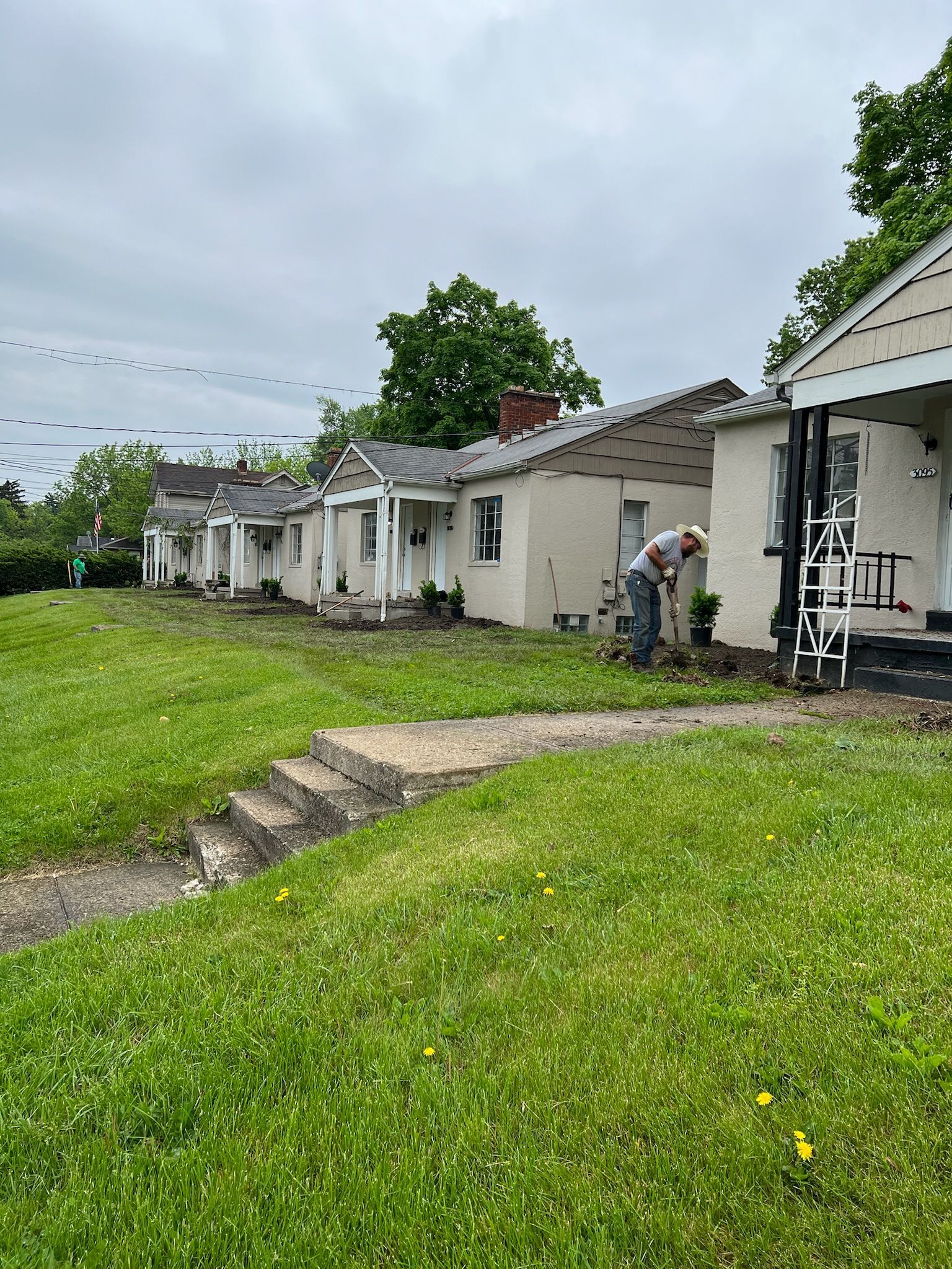 A man is standing in front of a row of houses.
