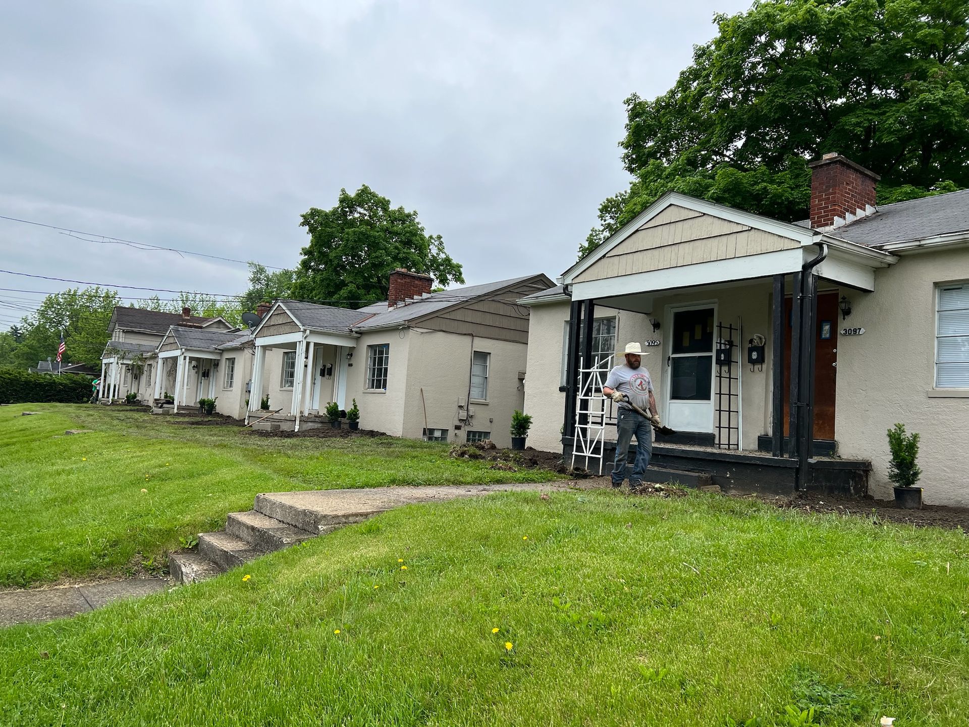A man is standing in front of a row of houses.