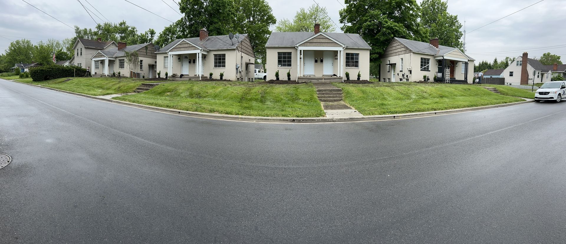 A panoramic view of a row of houses on the side of a road.