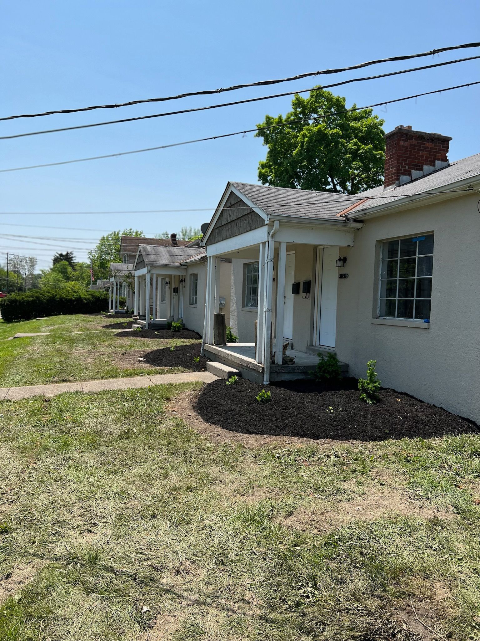 A row of houses sitting next to each other on a lush green field.